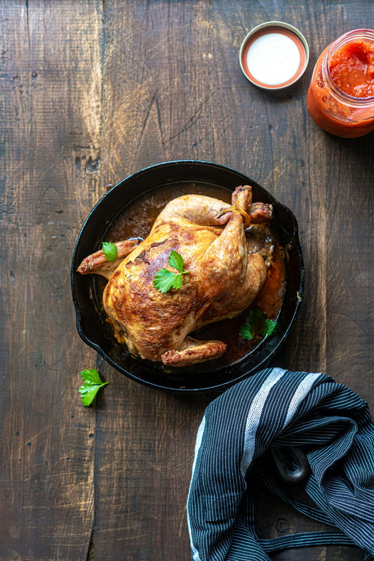 A well-seasoned black cast iron skillet on a worn wooden table.